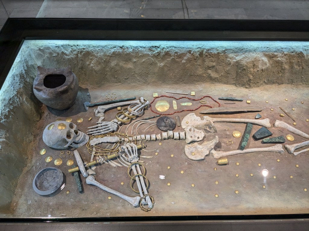 A photograph of the famed Grave 43 from the Varna Necropolis showing a reconstruction of the skeleton and it's associated grave goods.